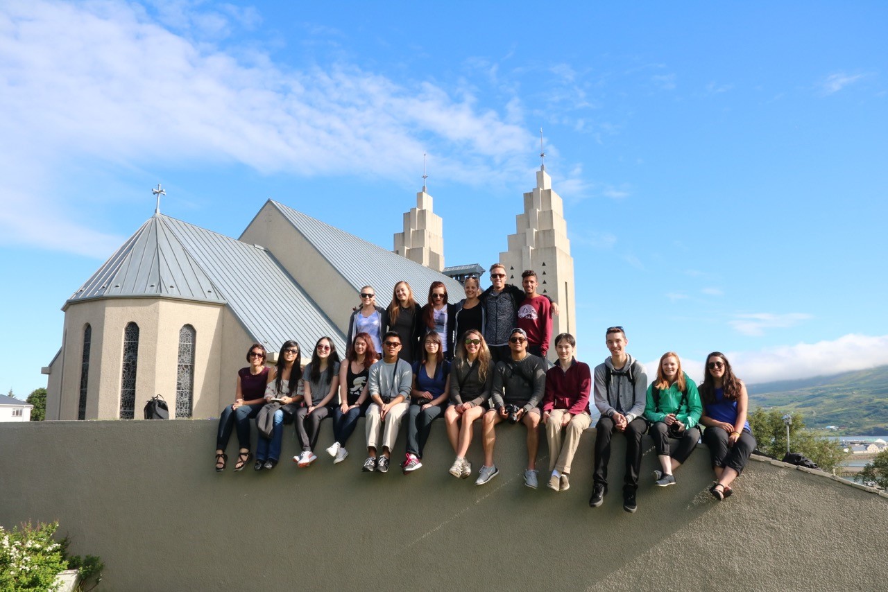 Group of students sitting on wall in front of building in Sweden