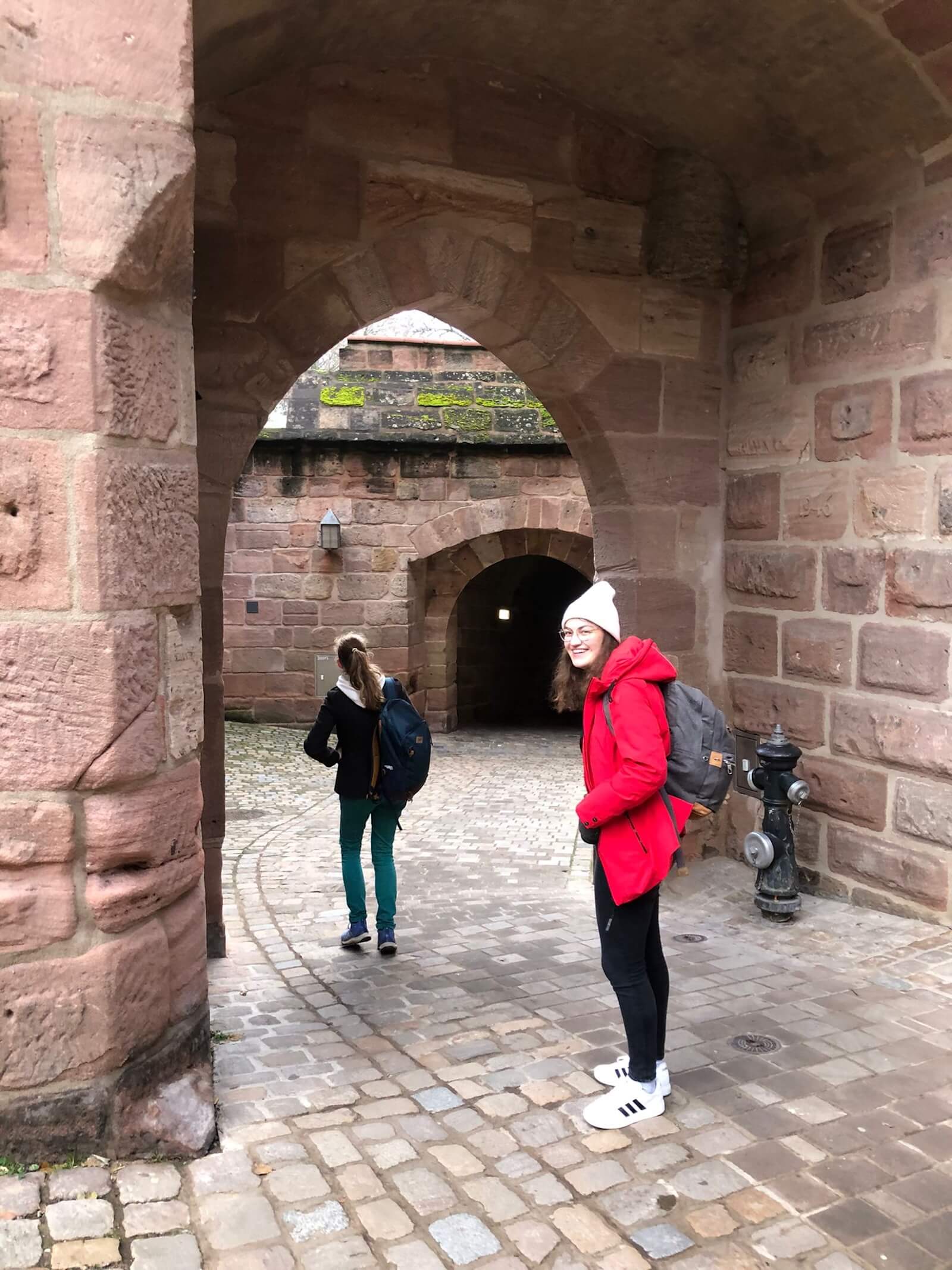 A student in red standing near a doorway
