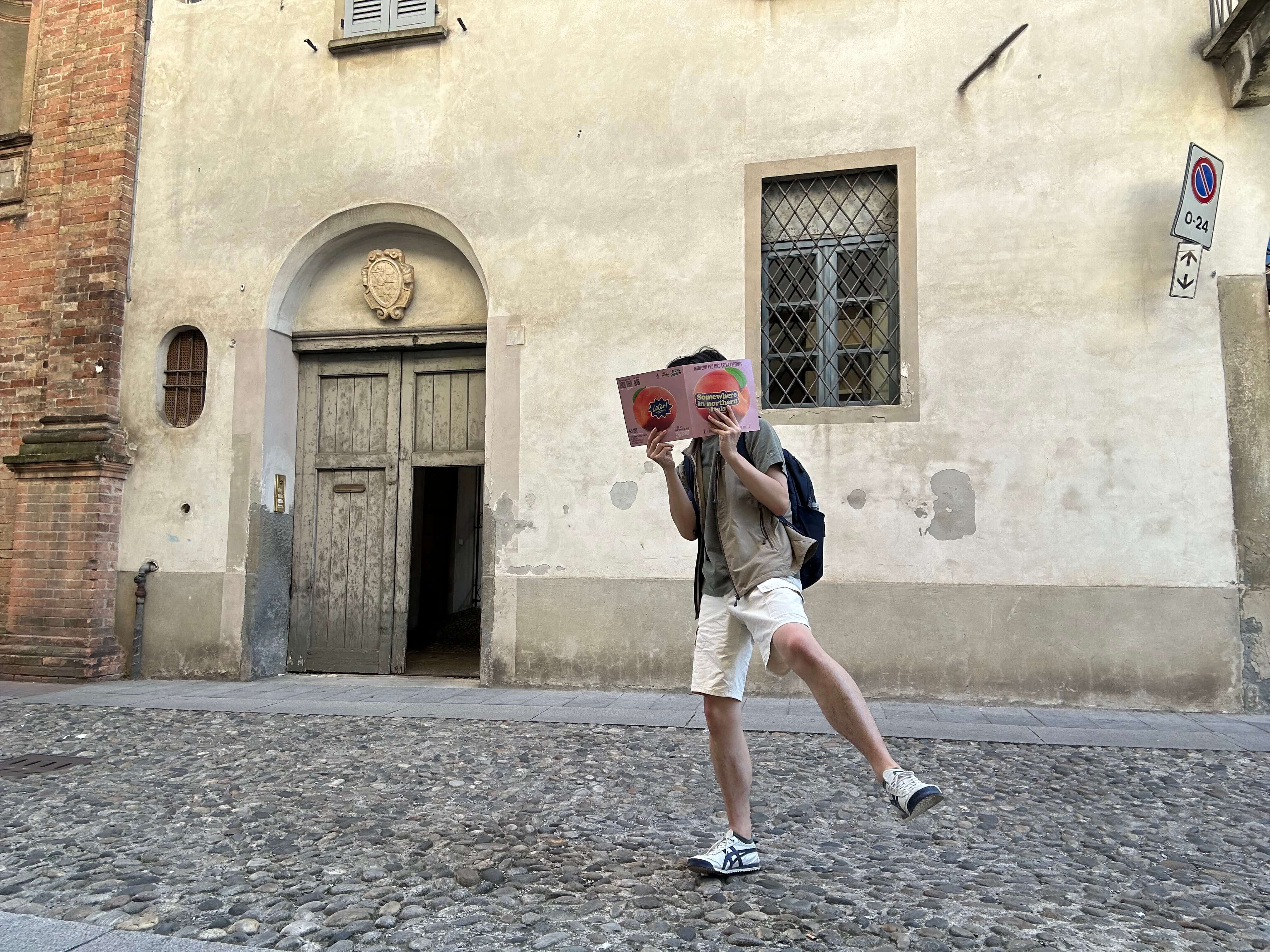 A person wearing shorts standing on one foot in front of a beige building