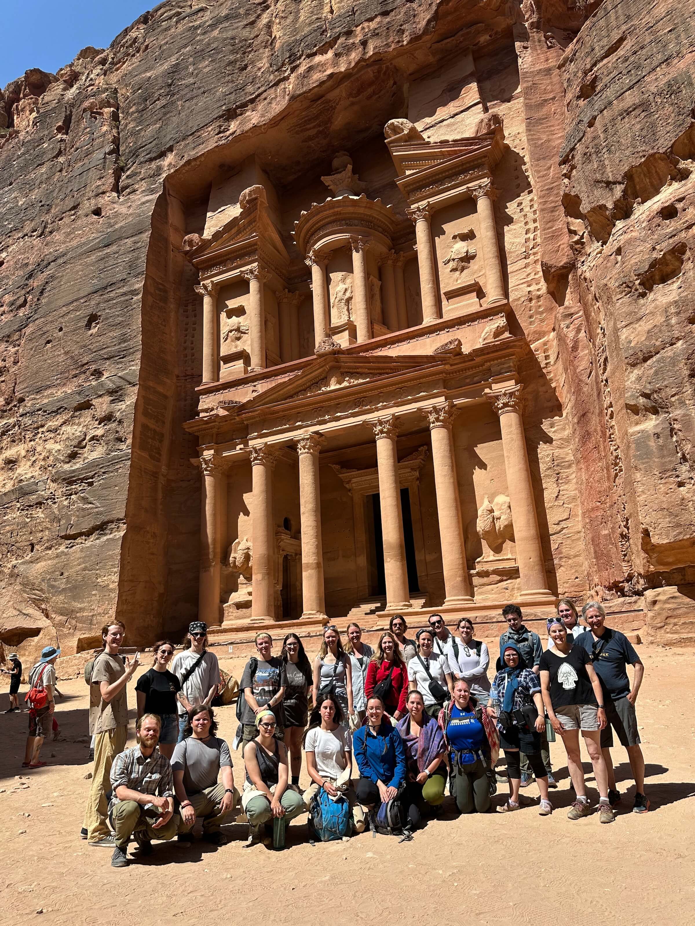 A group of students posing in front of a historical building